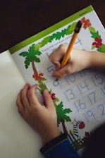 a child is writing on a sheet of paper