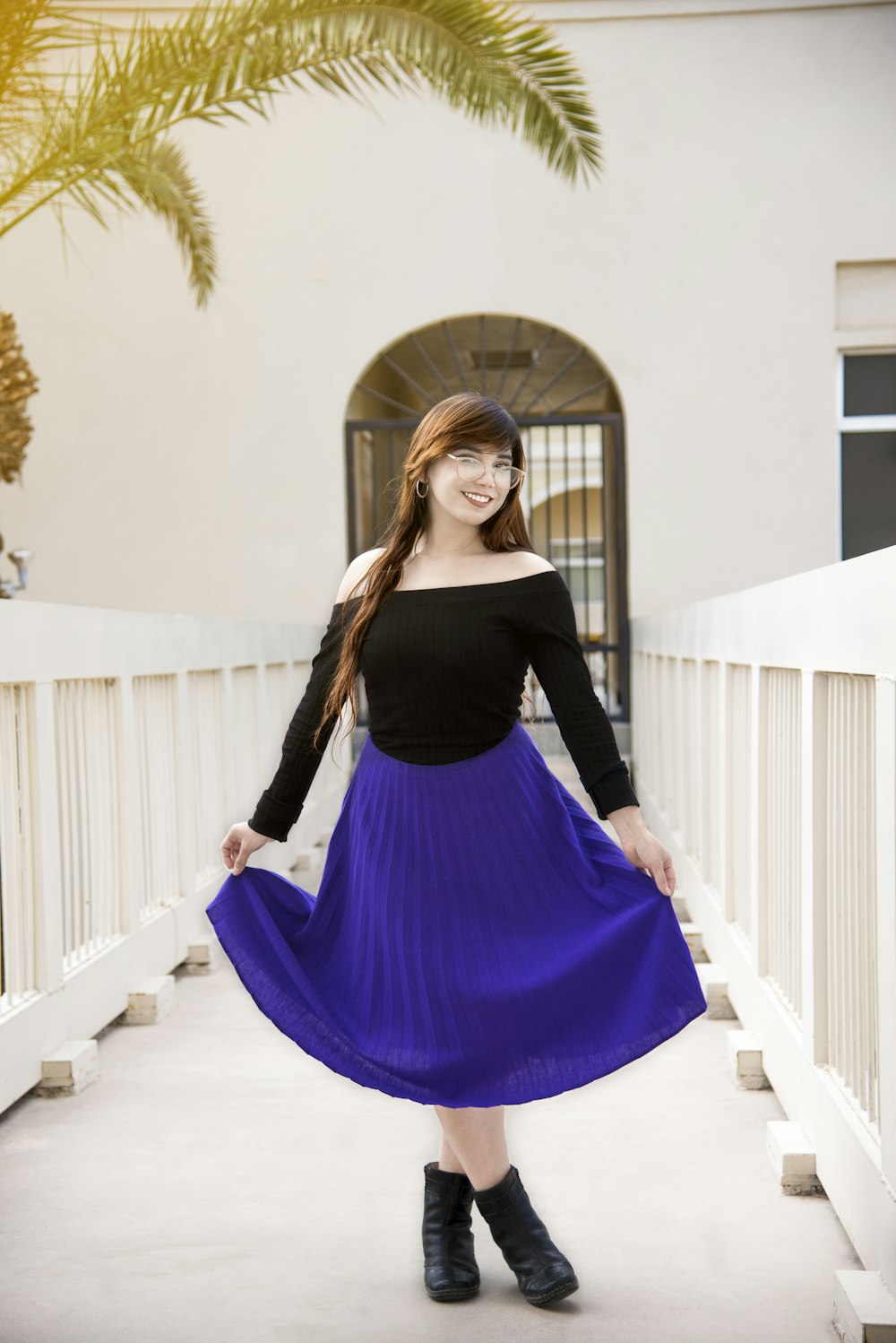 a woman in a black top and a purple skirt