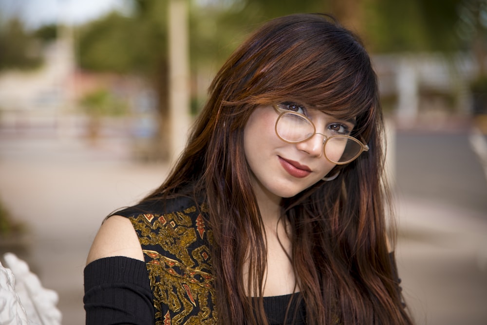 a woman with glasses is posing for a picture
