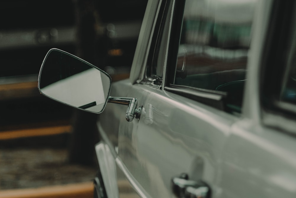 a side view mirror of a car on the side of the road