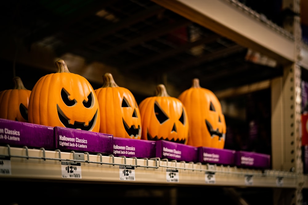 a row of jack o lantern pumpkins on a shelf