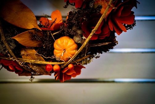 A vibrant autumn wreath adorned with colorful leaves and pumpkins.