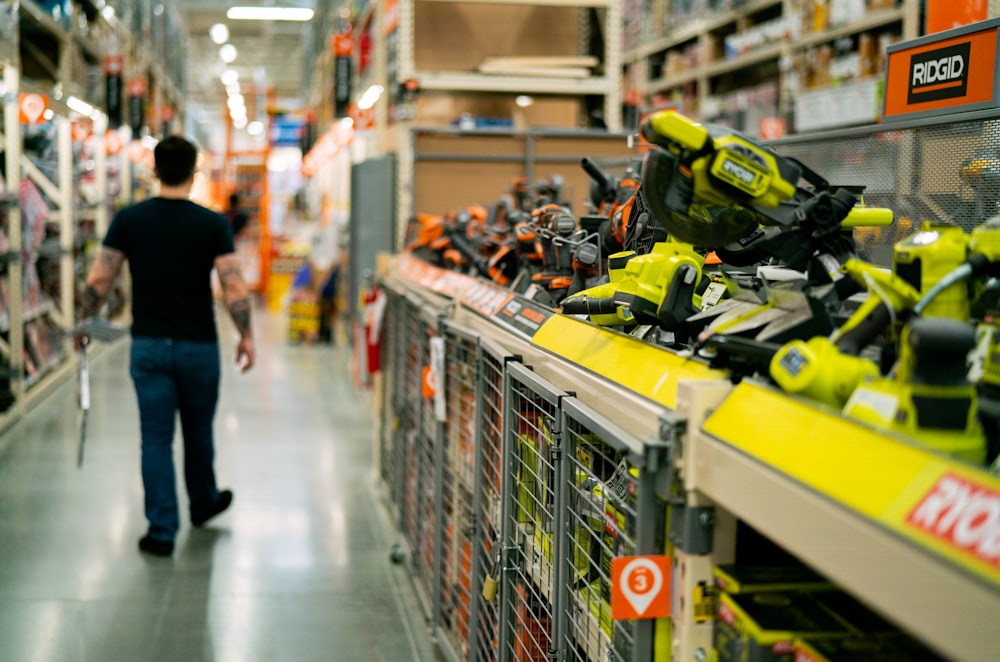 a man is walking down a store aisle