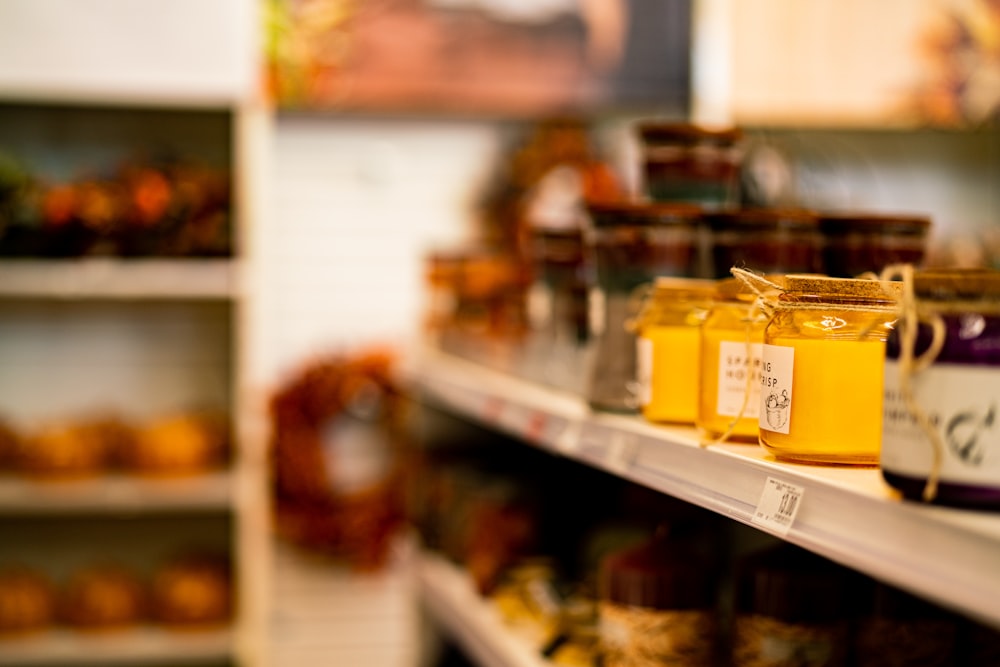 jars of honey sit on a shelf in a store