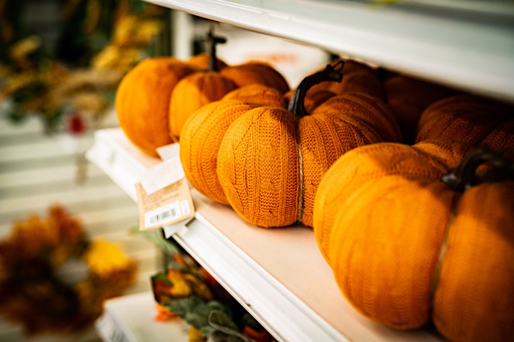 pumpkins are sitting on a shelf in a store