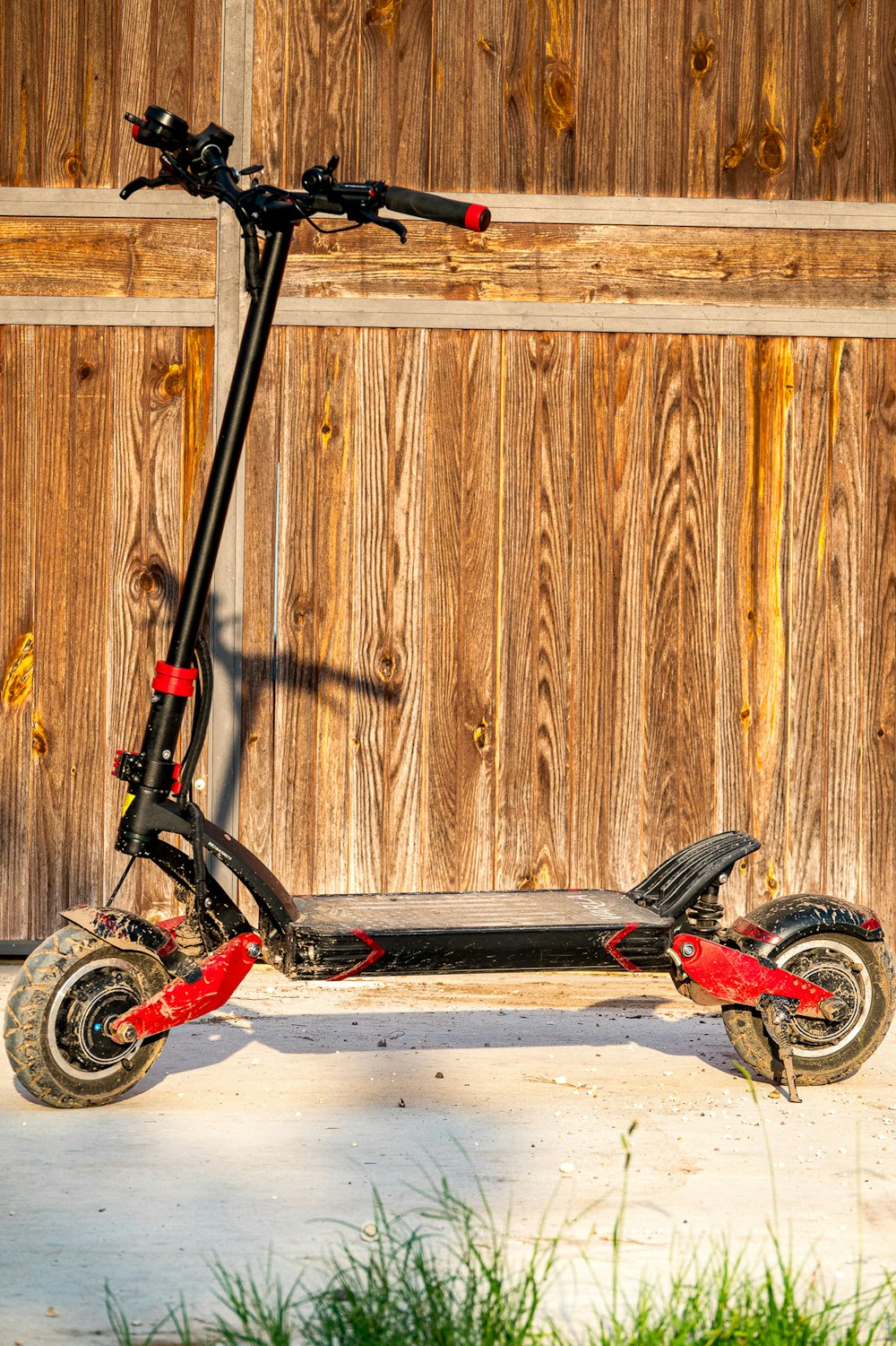 a scooter parked in front of a wooden fence