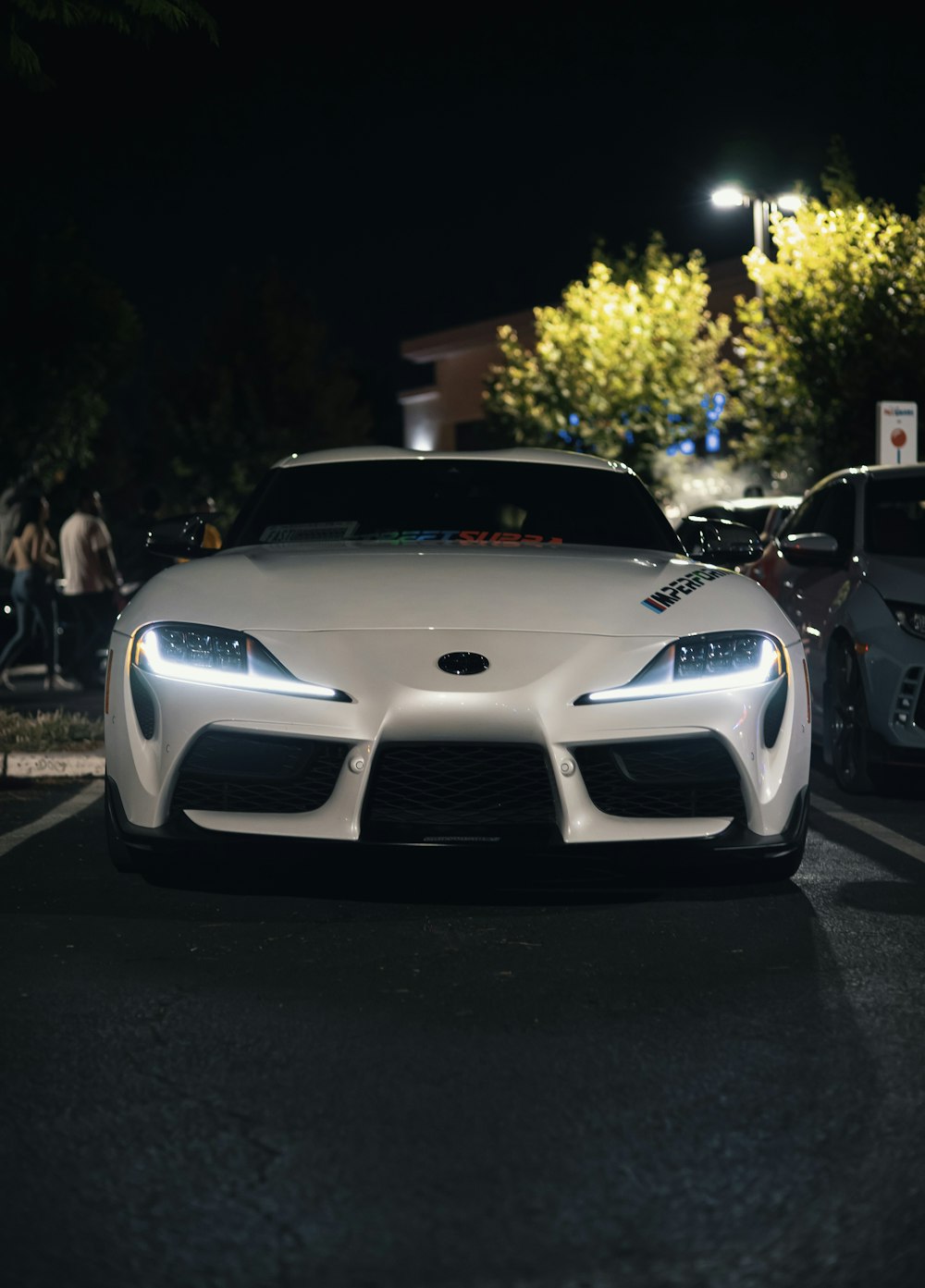 a white sports car parked in a parking lot