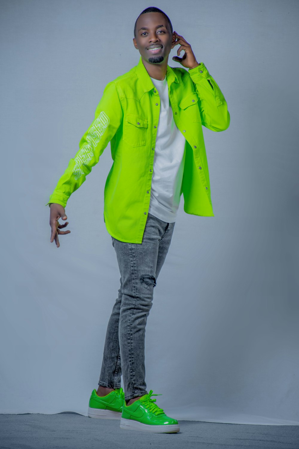 a man in a neon green jacket talking on a cell phone