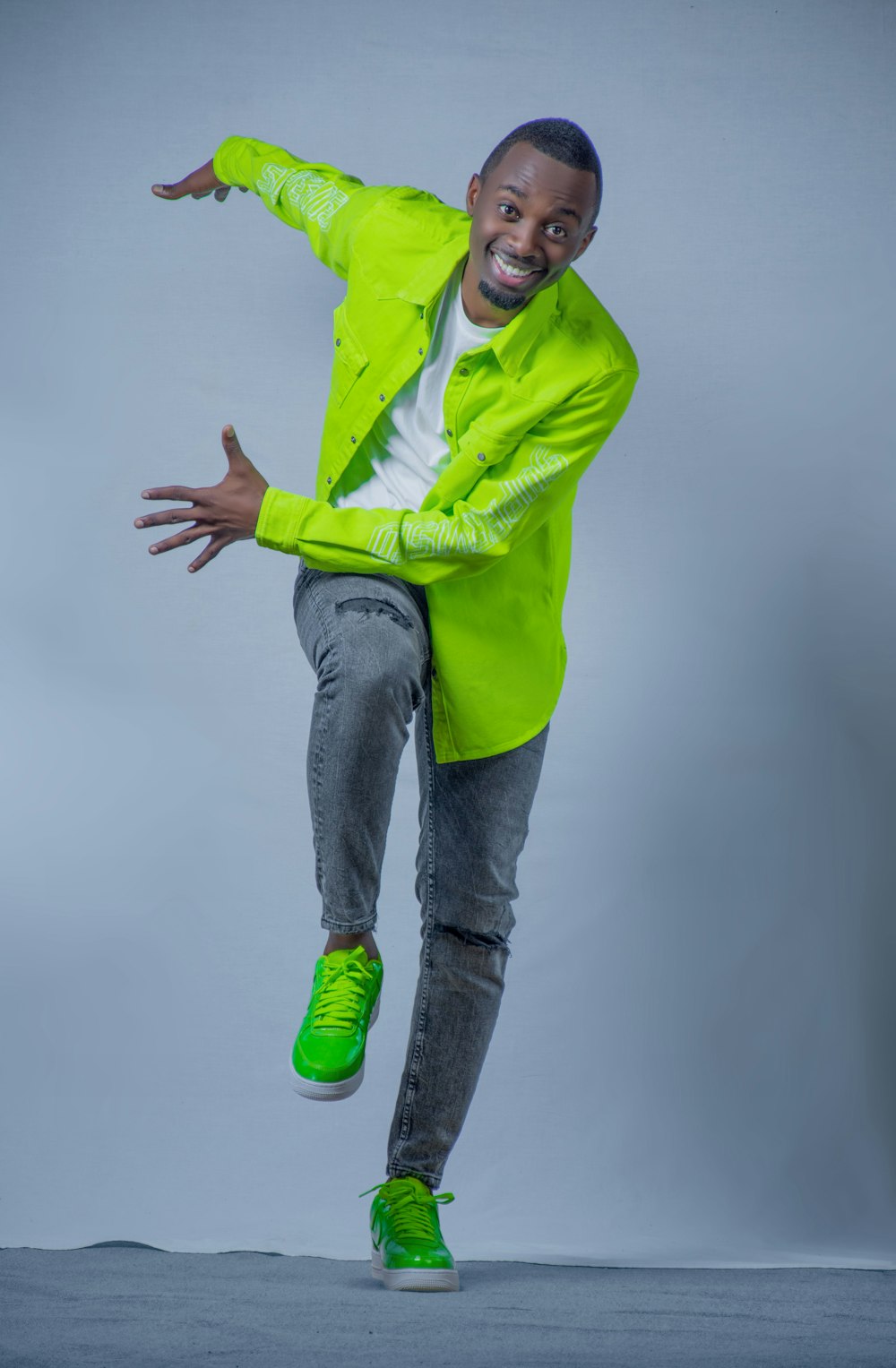 a man in a neon green jacket jumping in the air