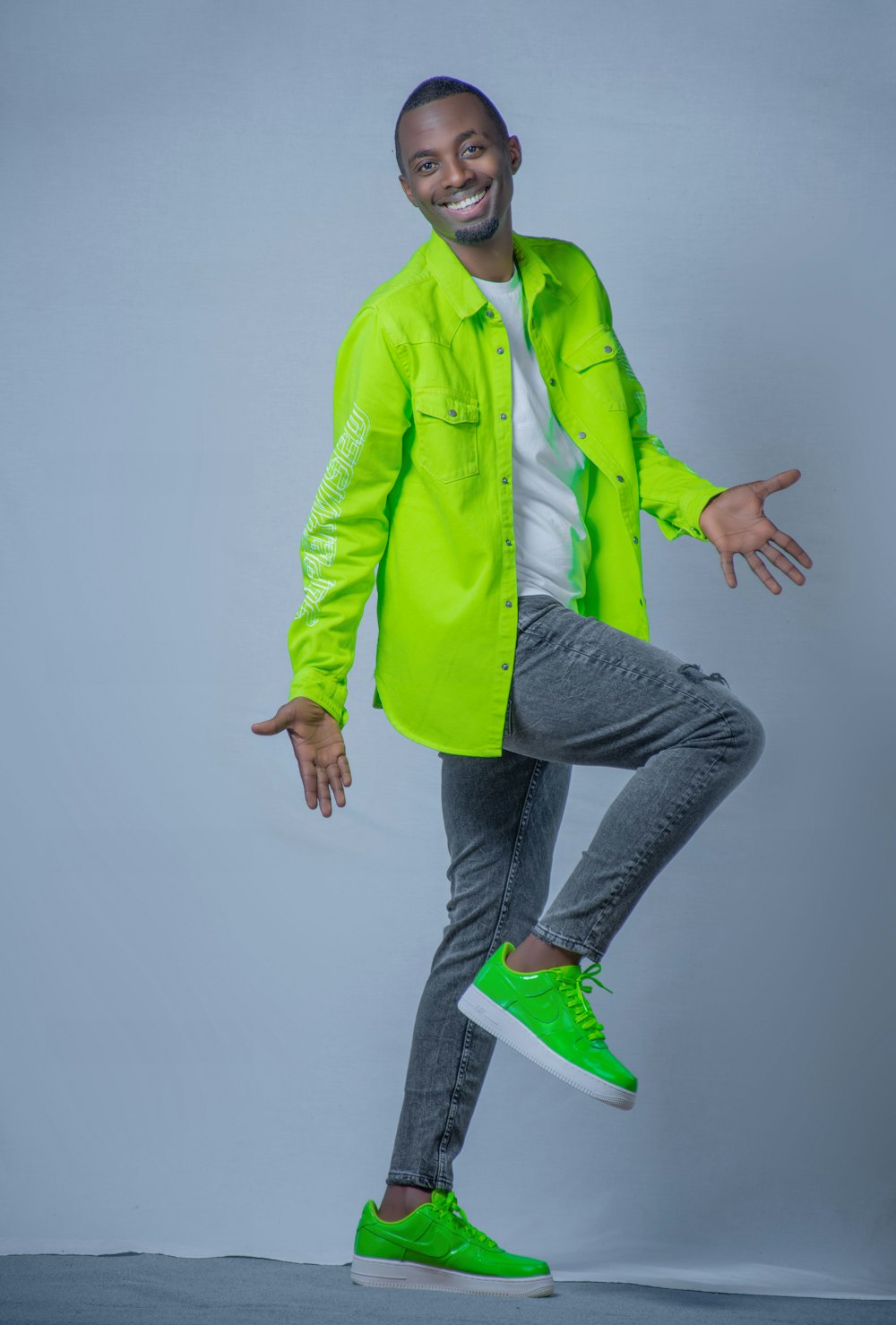 a man in a neon green jacket is dancing