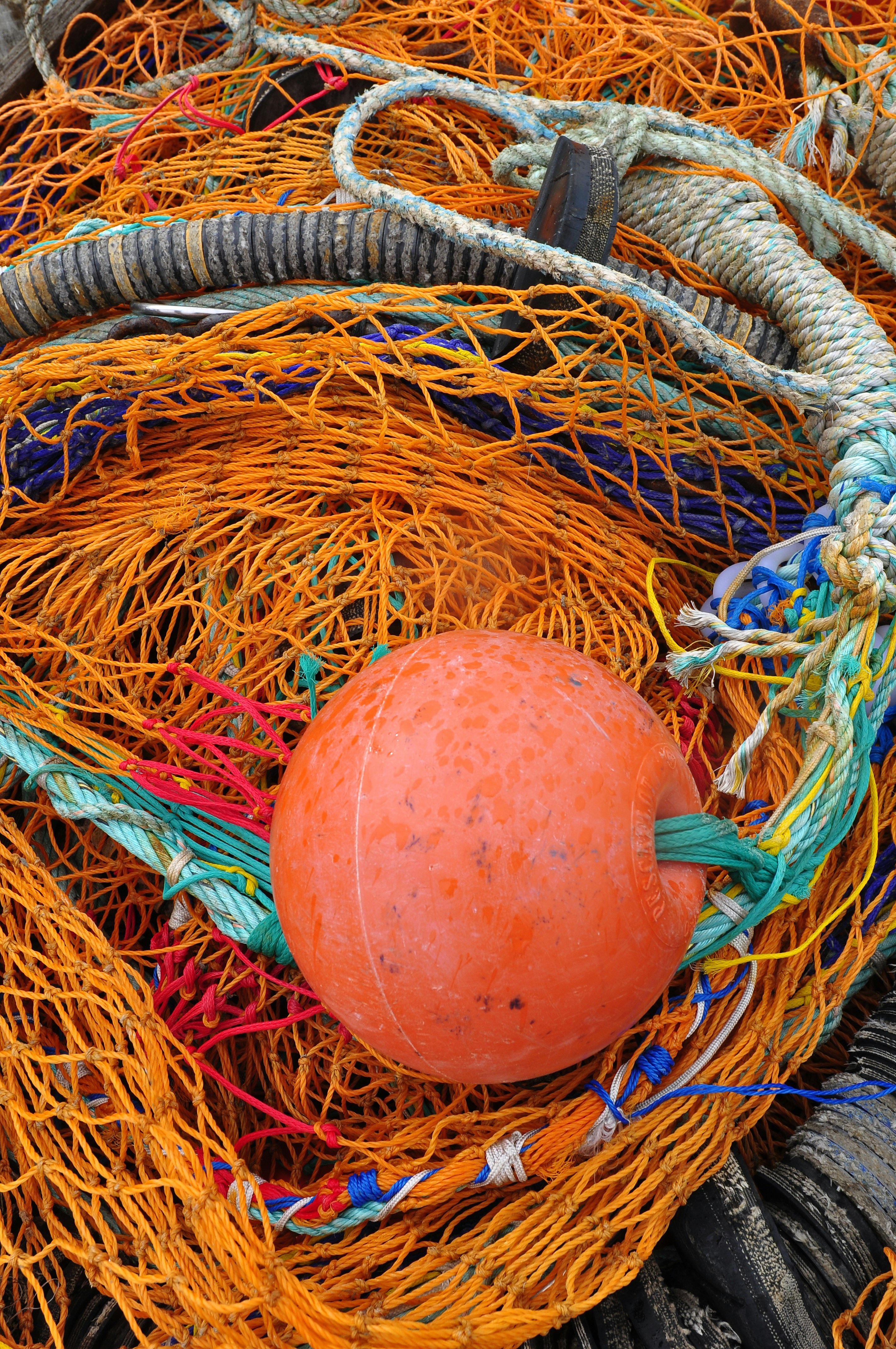 Ein orangefarbener Ball, der in einem Haufen Fischernetze sitzt