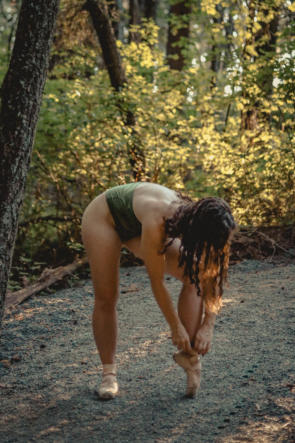 a woman bending over in the woods
