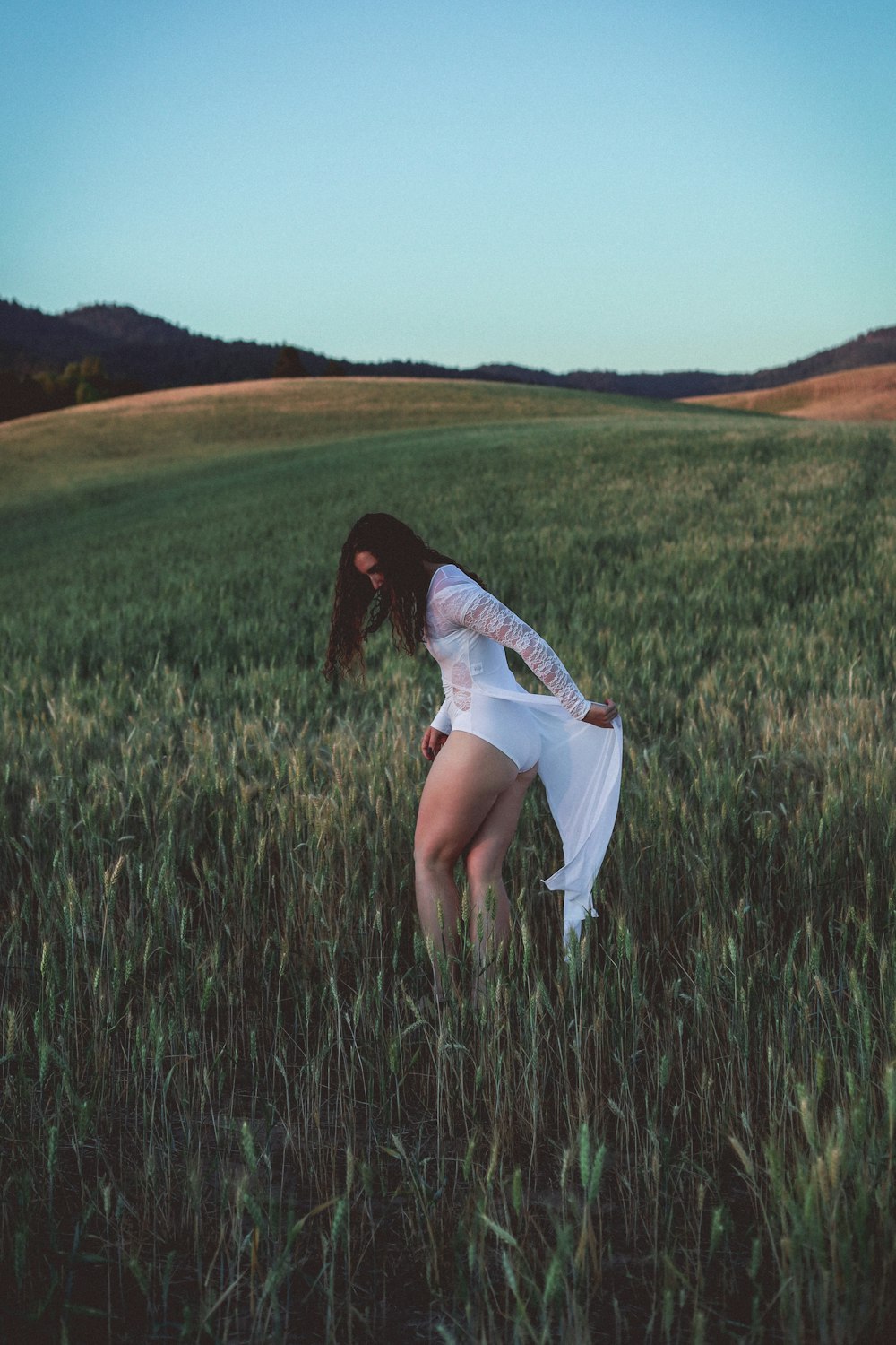 a woman standing in a field of tall grass