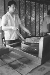 A professional fixing a stove in a bright, cozy kitchen setting.