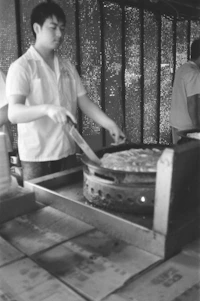 A skilled technician repairing an electric stove in a cozy Abu Dhabi kitchen.