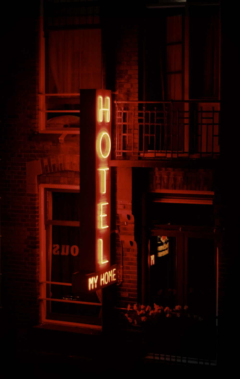 a hotel sign lit up in the dark