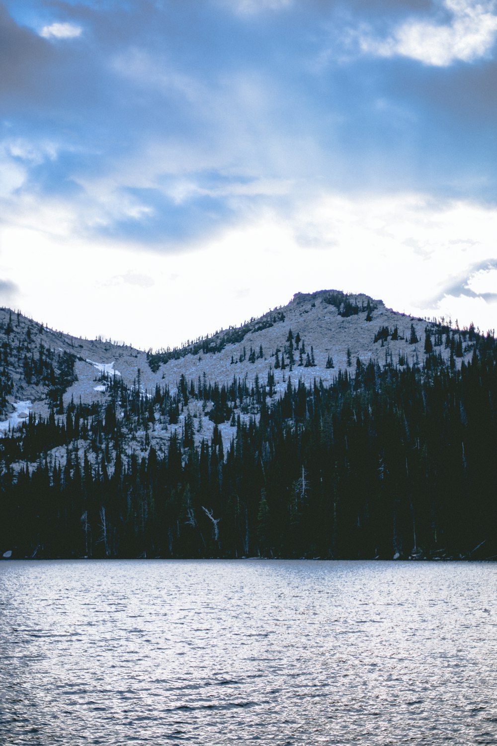 a large body of water with a mountain in the background