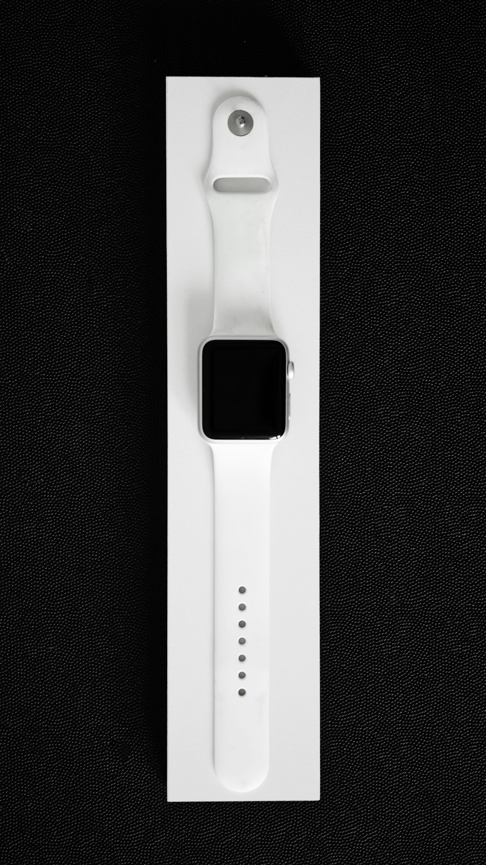 Eine Apple Watch in einer weißen Box auf schwarzem Hintergrund