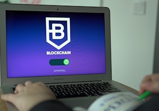 a person using a laptop with a blockchain logo on the screen