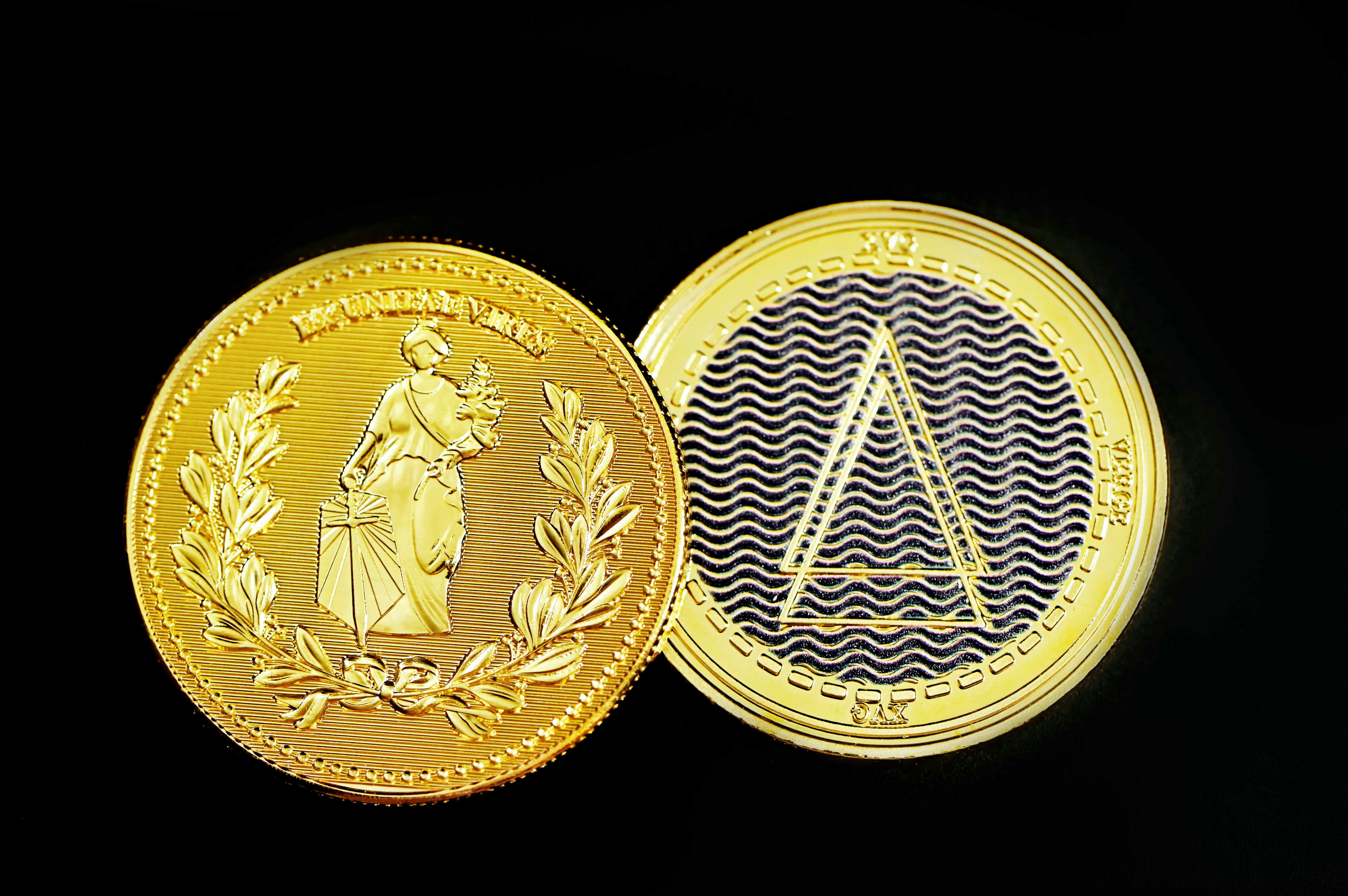 Two crypto coins placed on a black background