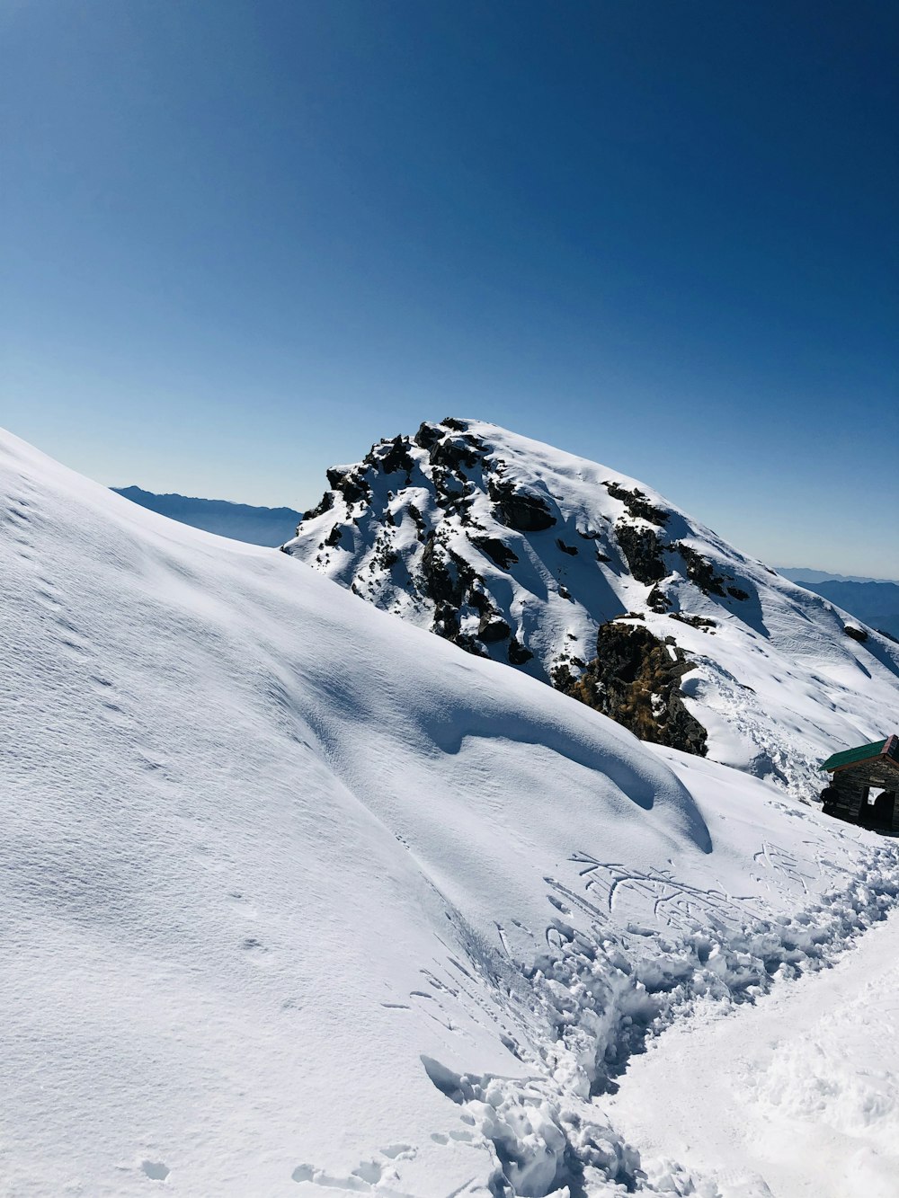 Ein Mann fährt auf Skiern einen schneebedeckten Hang hinunter