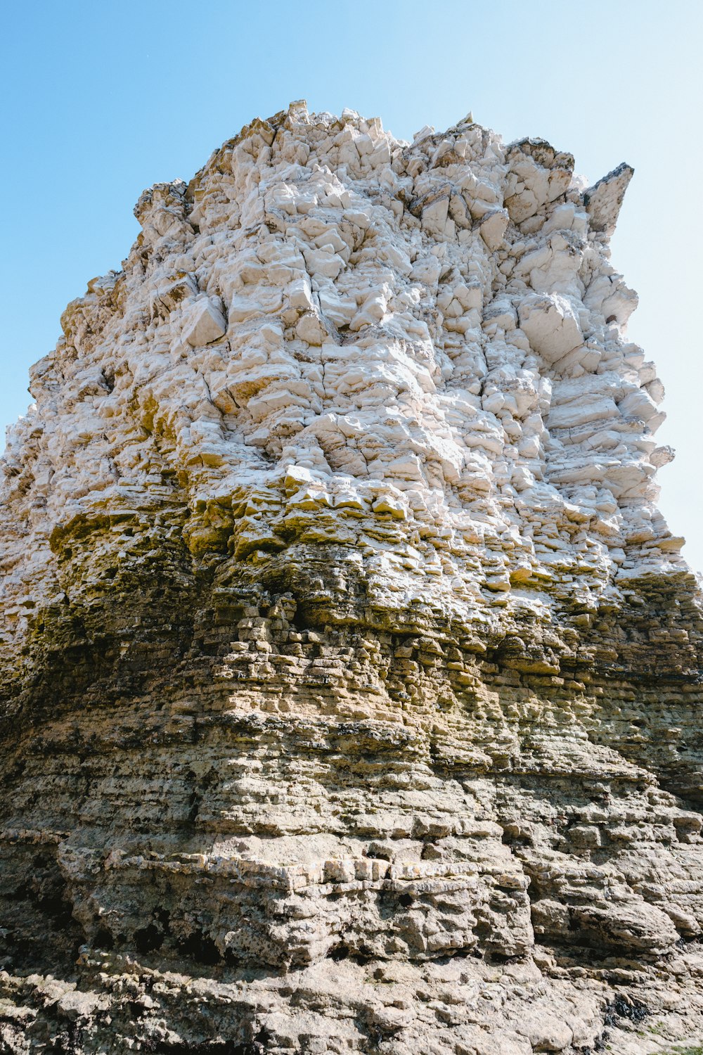 a very tall rock formation with moss growing on it