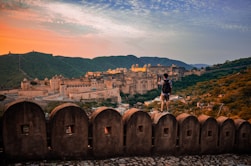 a man standing on top of a stone wall