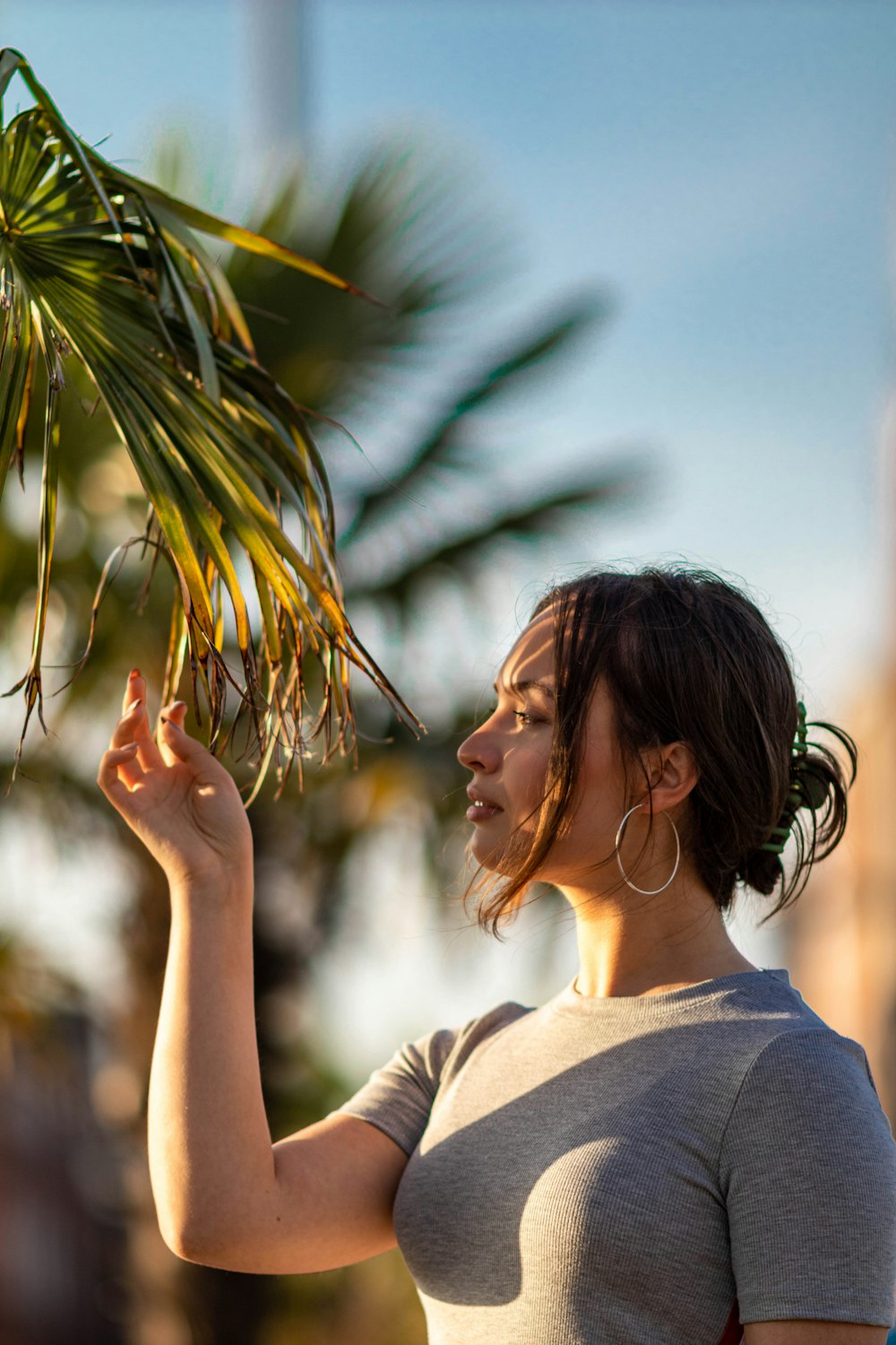 a woman holding a palm tree in her hand
