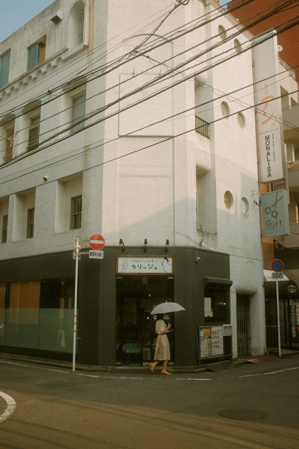 Une femme tenant un parapluie debout devant un immeuble