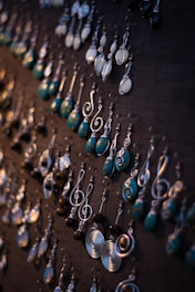 A collection of different piercing styles displayed on a wooden board.