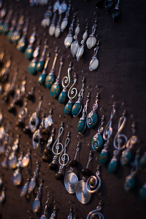 Close-up of colorful handmade earrings displayed on a rustic wooden surface