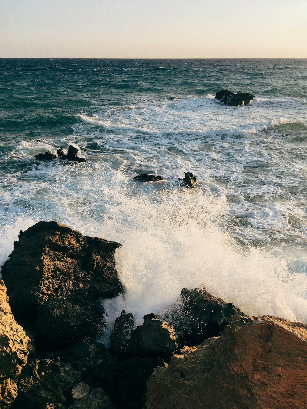 Una orilla rocosa con olas rompiendo contra las rocas