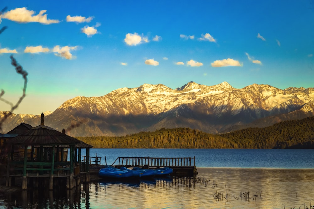 a lake with a dock and mountains in the background