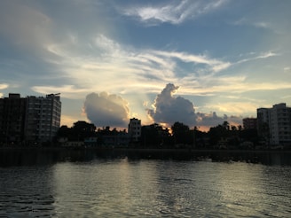 High-rise building overlooking a calm lake at sunset