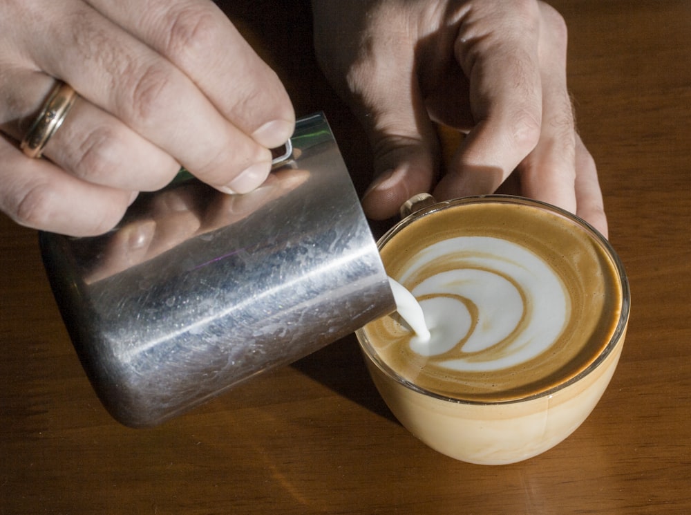 a person is pouring something into a cup