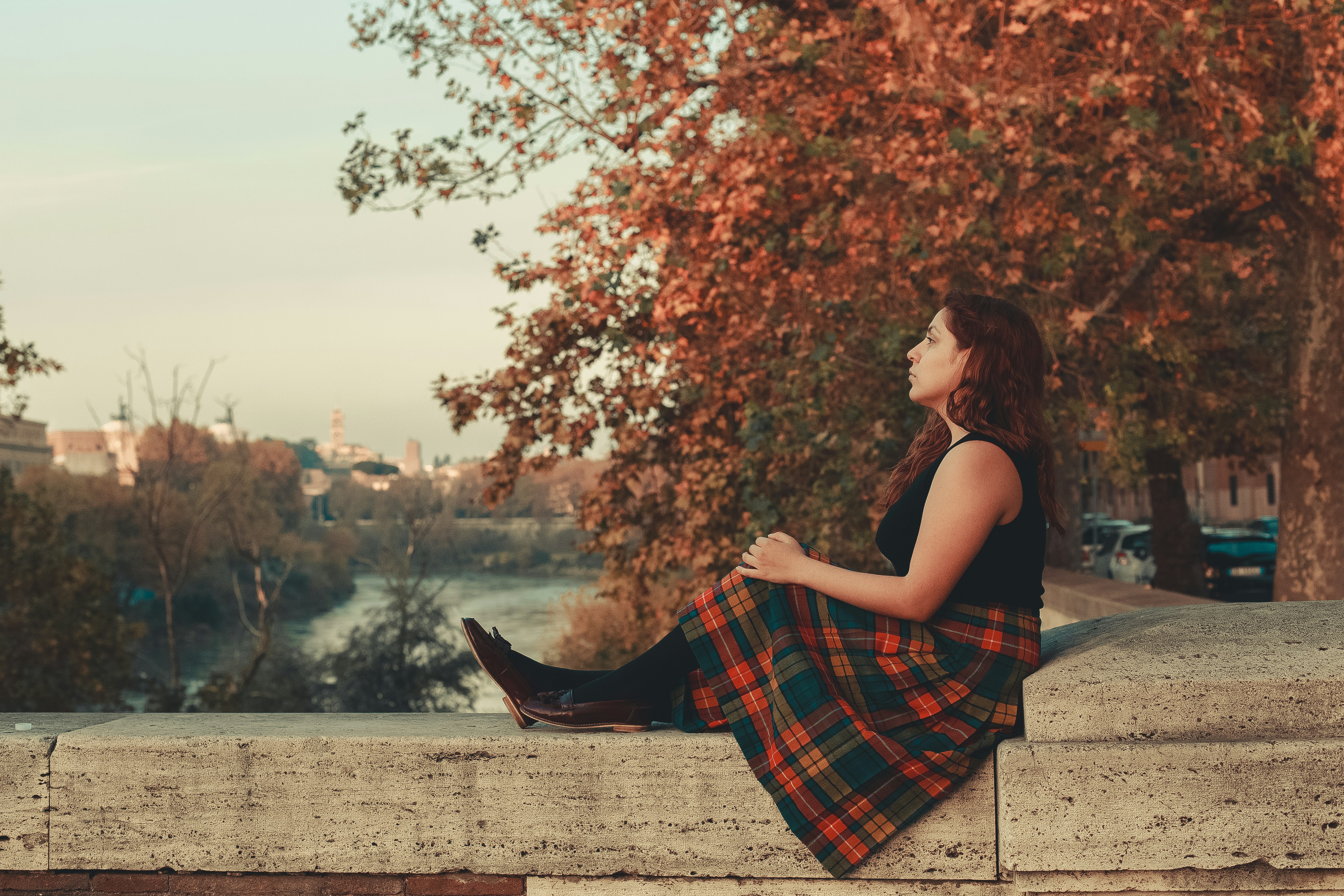 a woman sitting on a ledge with her legs crossed