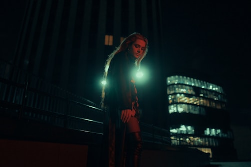 A cinematic shot of a realistic AI-generated character in a moody neon-lit cityscape.