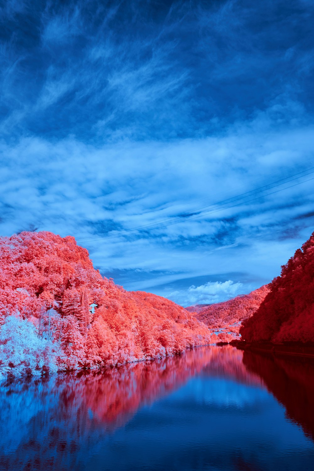 a body of water surrounded by red hills