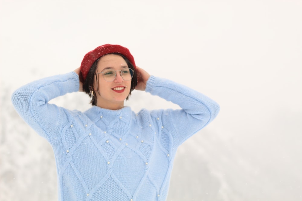 a woman wearing a blue sweater and a red hat