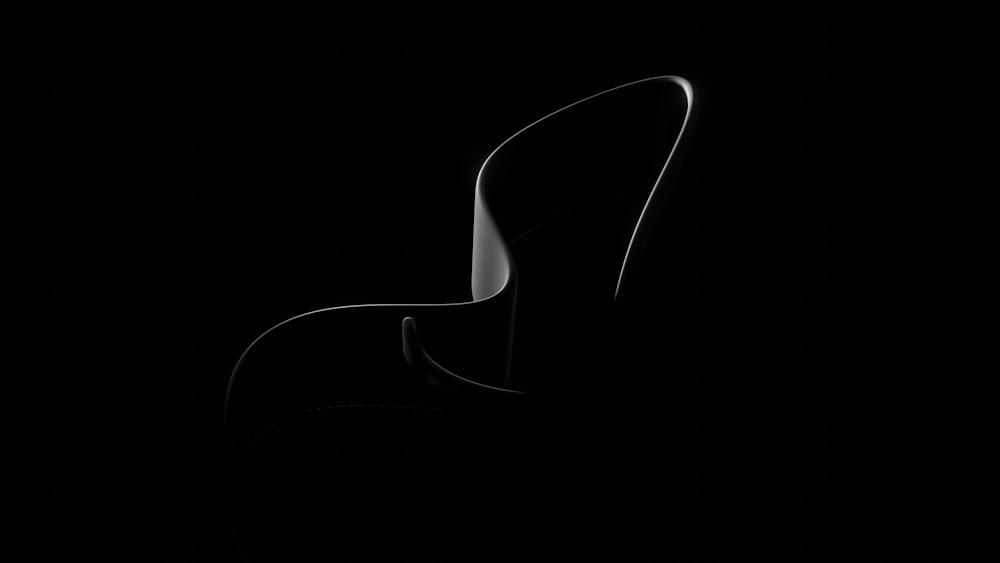 a black and white photo of a chair in the dark