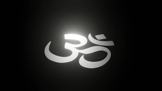 Large italic serif Sanskrit text glowing softly against a deep brownish-black backdrop.