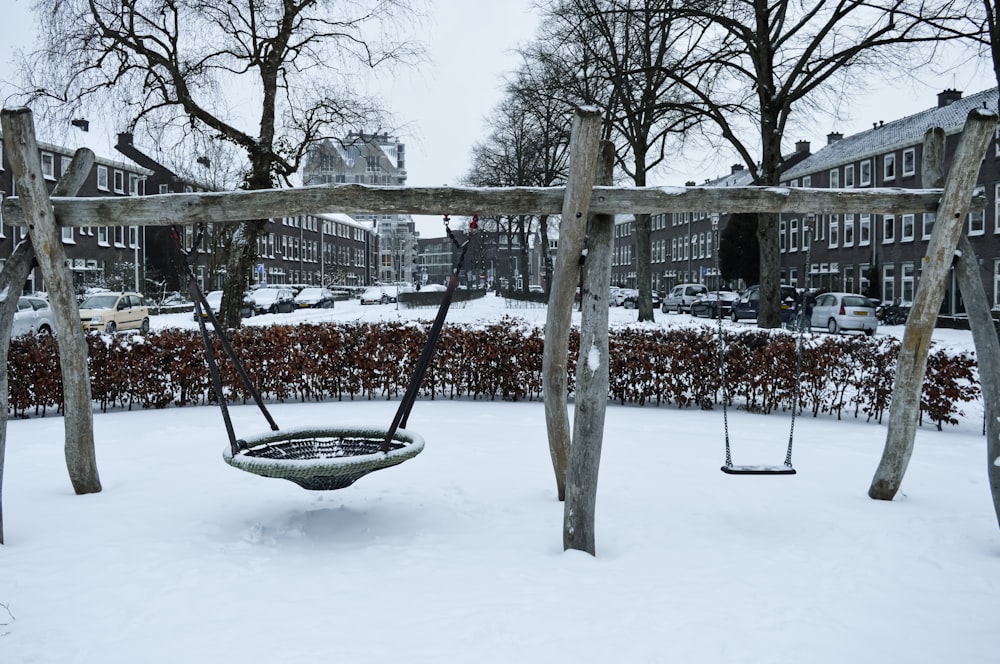 a snow covered park with a swing and swings