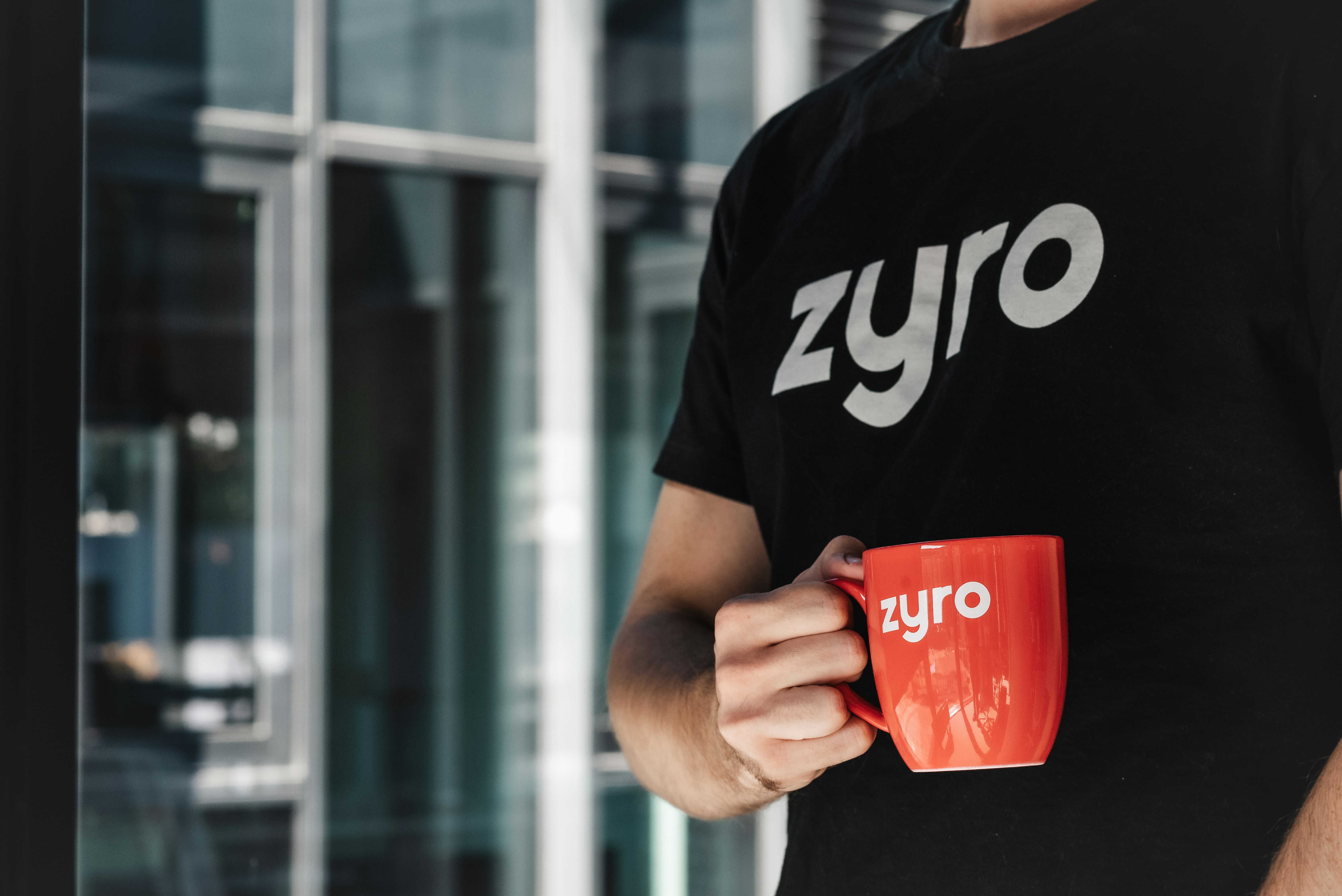 a man is holding a red coffee mug