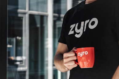 a man is holding a red coffee mug
