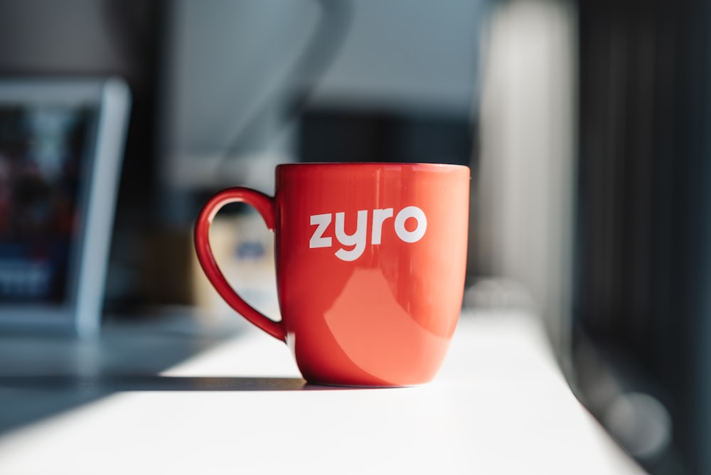 a red coffee cup sitting on top of a table