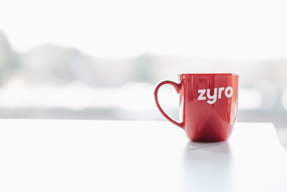 a red coffee mug sitting on top of a table