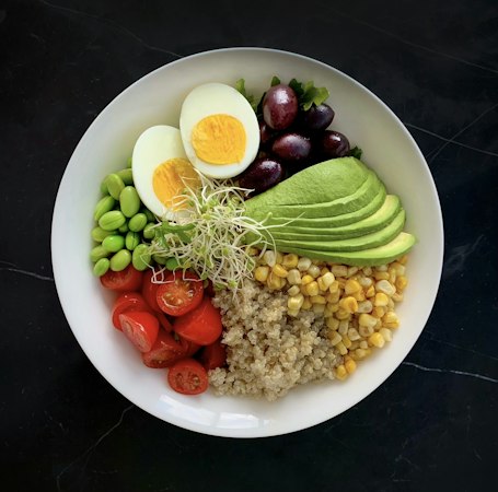 A white bowl filled with vegetables and eggs