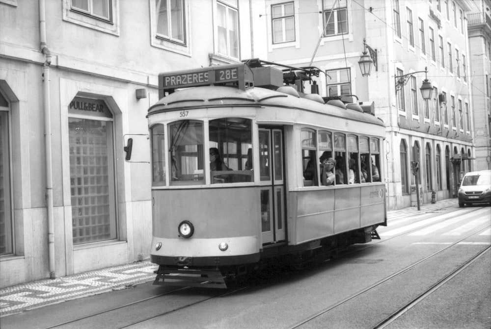 a black and white photo of a trolley on a street