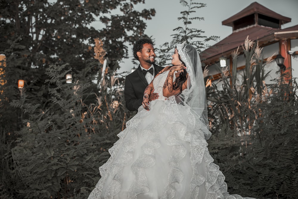 a bride and groom standing in front of a building