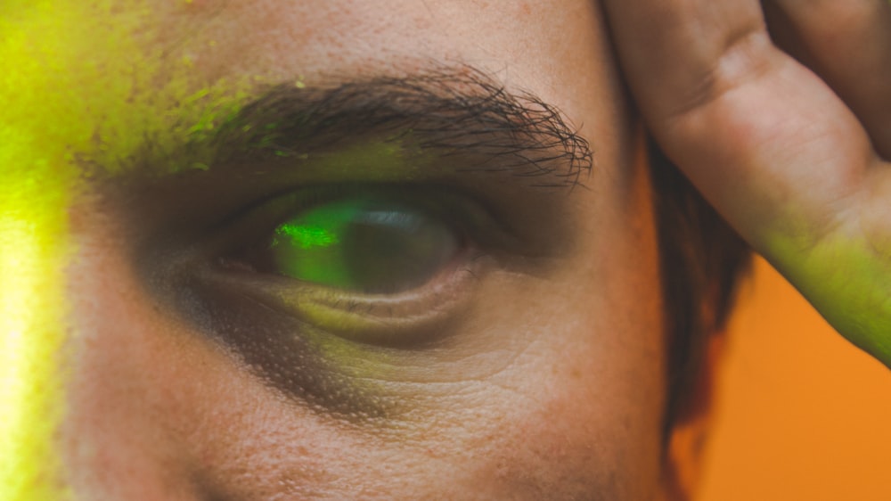a close up of a man's face with a green eye